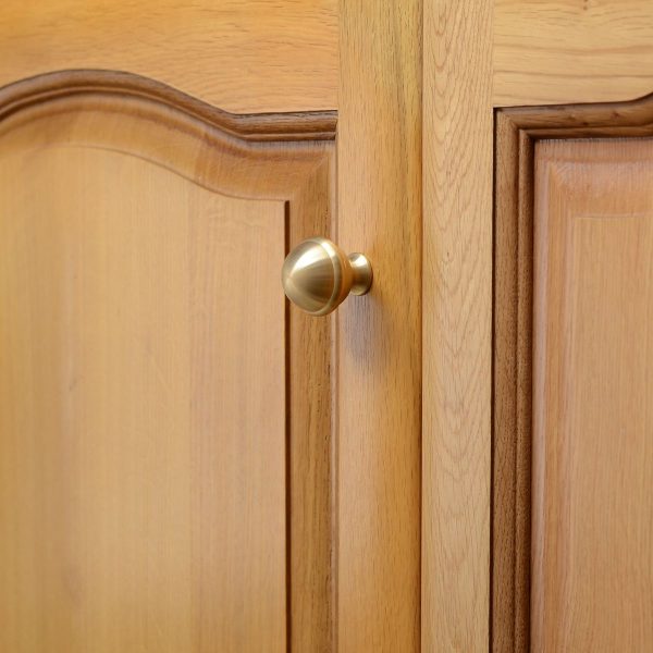 solid-brass-cupboard-knob-ringed-ball-large-3 solid brass cupboard knob shaped like a ringed-ball, mounted to a wooden cupboard door