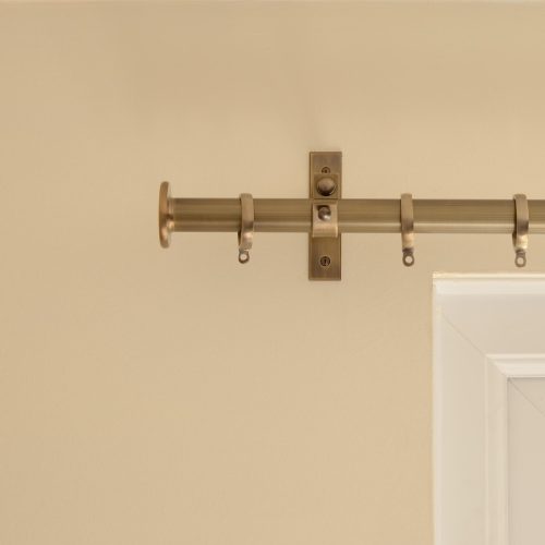solid brass button shaped curtain finial on curtain pole