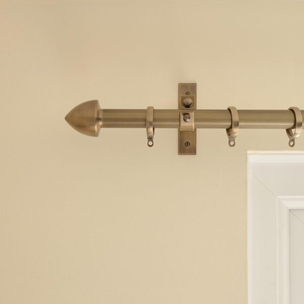 solid brass point shaped curtain finial, mounted on curtain pole, in antique finish