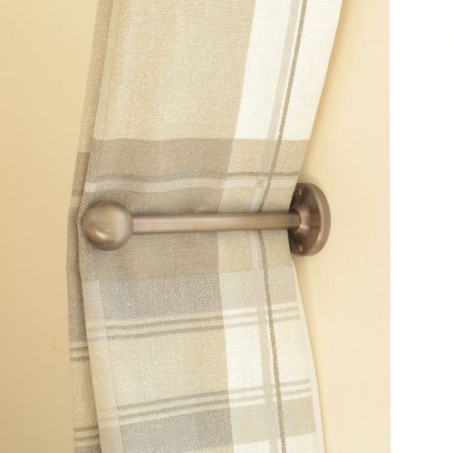 solid brass curtain holdback with ball shaped end in antique finish shown in use