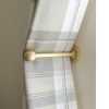 solid brass curtain holdback with ball shaped end shown in use