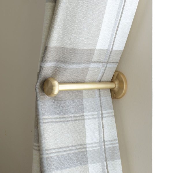 solid brass curtain holdback with button shaped end, shown in use.