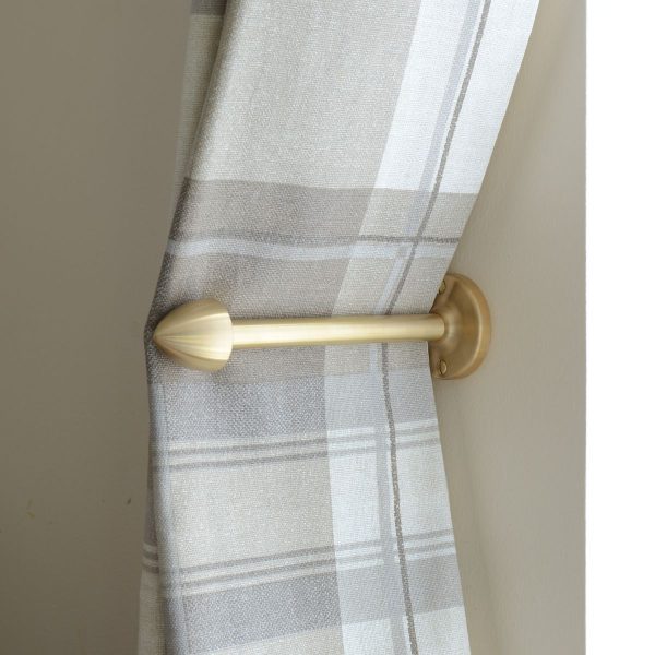 solid brass curtain holdback with pointed end, shown in use.