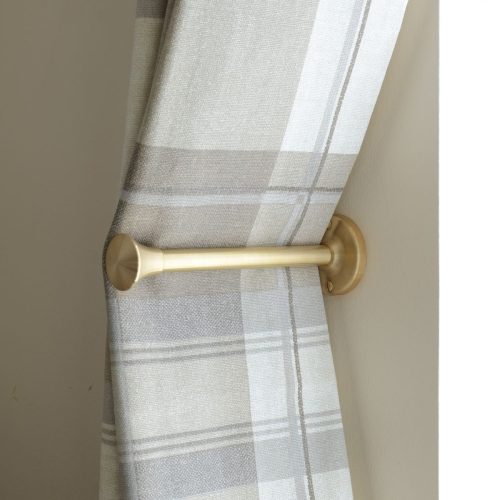 solid brass curtain holdback with trumpet shaped end, shown in use.