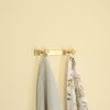 solid brass double wall hanger hook with a towel hanging from it