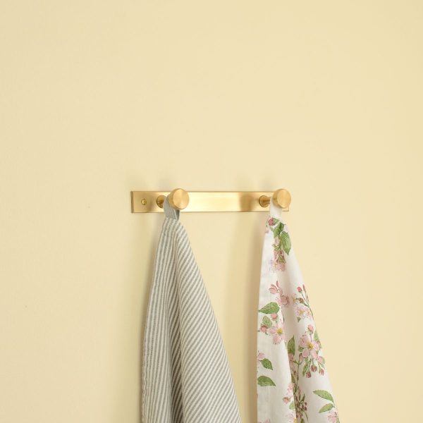solid brass double wall hanger hook with a towel hanging from it