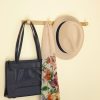 solid brass quad wall hanger hook, shown holding a bag, a hat and a scarf.