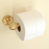 solid brass toilet roll holder mounted to a wall, shown with a toilet roll.