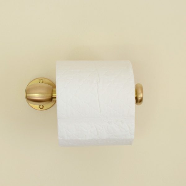 solid brass toilet roll holder mounted to a wall, shown with a toilet roll.