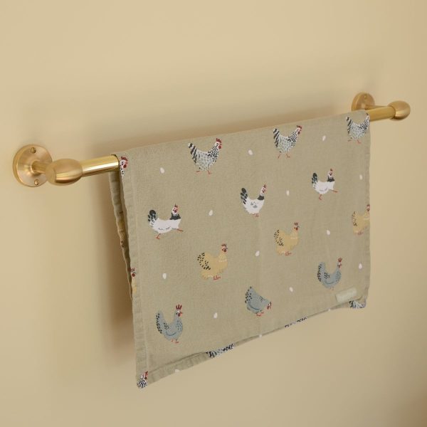 solid brass towel rail mounted to wall, shown with a towel.